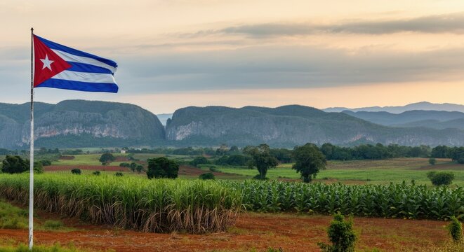 Cuban flag waving in scenic countryside with mountains background