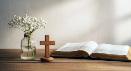 Open Bible, wooden cross, glass vase with white flowers on table