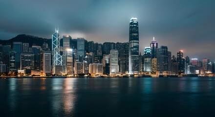 Fototapeta premium A panoramic view of a city skyline at dusk with glowing lights reflecting on the water