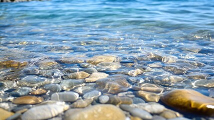 Obraz premium Clear water with visible pebbles on shore
