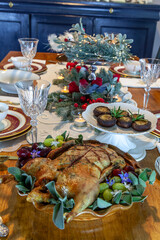 Roasted duck on a platter with sage leaves and grapes