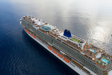 Luxury Cruise Ship Sailing in Blue Ocean Waters, Modern Passenger Vessel with Swimming Pools,...