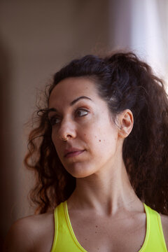 Close up portrait of Woman looking up wearing a bright yellow sports top