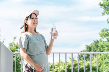 運動・ウォーキング中に水分補給する妊婦・プレママ
