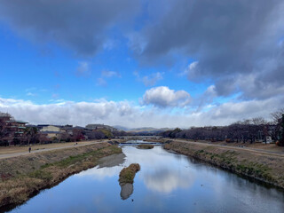 冬の京都の鴨川丸太町橋から望む北山の時雨れ