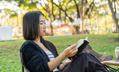 Young girl reading a book in the park, concept of Relaxation, solitude with nature.