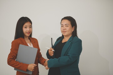 Two young professional women looking at a digital tablet isolated on white background