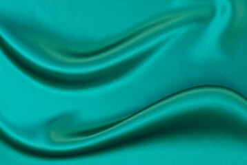 Black green satin dark fabric texture luxurious shiny that is abstract silk cloth background with patterns soft waves blur beautiful.