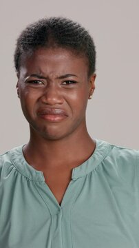 Black woman, expression and disgust for disapproval, negative emotion and gross smell as reaction. Female person, unhappy and annoyed on white background as cringe, stink and frustrated by nasty odor