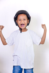 A cheerful asian child wearing a helmet, celebrating with raised fists and a bright smile.