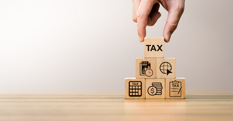 Hand Arranging Wooden Blocks with Tax Symbols, Representing Financial Planning, Tax Filing, and...
