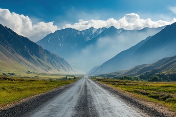 Scenic mountain road disappearing into a valley under a vibrant summer sky.