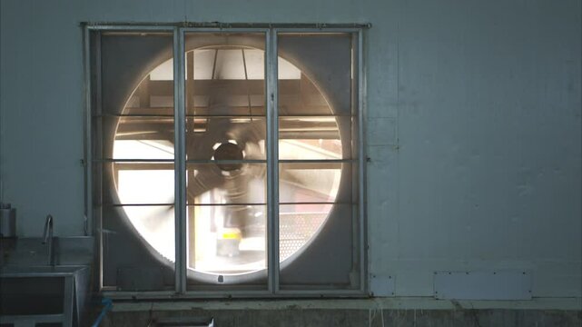 Large exhaust fan in a canned fish factory is used to extract heat and odor