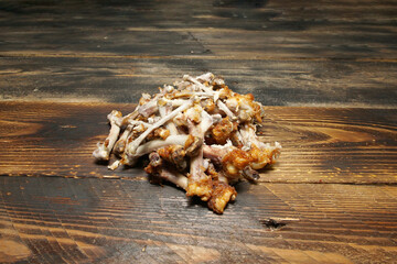 The bones from the chicken wings are lying on the old wooden table. Leftovers. A ready-made dog...