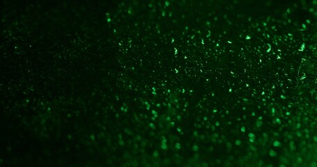Wet texture. Water drops. Sparkling colorful green fluid rain water gleaming blinking liquid on abstract bokeh light art background.
