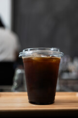 Close up of iced americano coffee with ice cubes in a takeaway glass