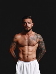 Fototapeta premium Fitness model showcasing physique in studio portrait photography dark background strong expression