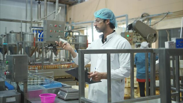 The production control supervisor inspects and controls the operation of machines in the manufacturing line of a canned fish industry