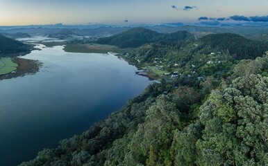 Misty morning view of a New Zealand town nestled beside a river. Tranquil landscape. OPOUTERE, COROMANDEL PENINSULA, NEW ZEALAND