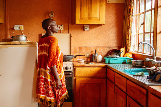 A young African  woman doing her chores in the kitchen