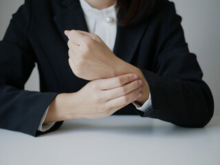 Young Asian woman feels numbness and severe pain in her wrist Caused by sitting and working for a...