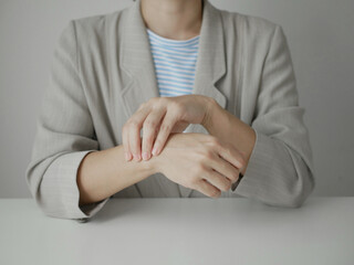 Fototapeta premium Young Asian woman feels numbness and severe pain in her wrist Caused by sitting and working for a long time Health care and office syndrome concept