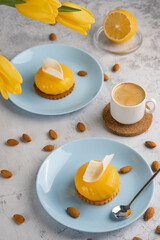 Yellow cupcakes and cup of coffee with yellow tulips on concrete background. Tasty morning dessert