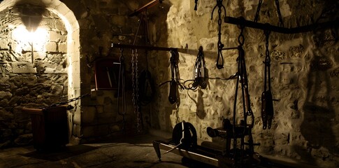 Grim medieval torture chamber with cold stone walls and eerie atmosphere.