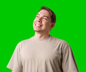 Smiling man in a beige shirt poses against a bright green background