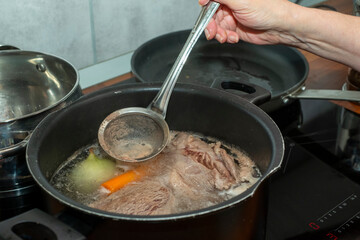 skimming off broth foam