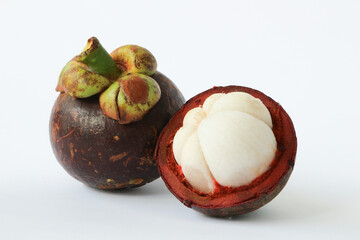 Manggis (Garcinia mangostana L), Fresh ripe mangosteen fruits and cross section showing the thick purple skin and white flesh.