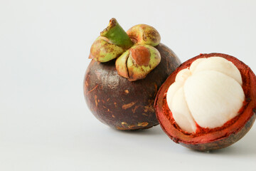 Manggis (Garcinia mangostana L), Fresh ripe mangosteen fruits and cross section showing the thick purple skin and white flesh.