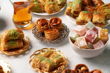 Delicious assortment of traditional sweets and desserts featured on a table with a glass of tea