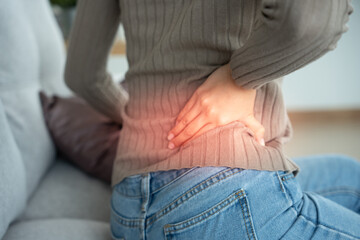 woman holding her lower back while and suffer from unbearable pain health and problems, chronic...