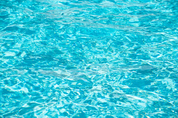 Obraz premium Blue pool water background. Blurred transparent clear calm water surface texture. Water waves in sunlight with copy space.