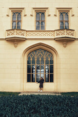 In the center of the photo is a large window with elegant decorative elements. Above it are two...