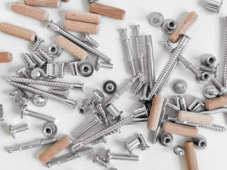 Assorted hardware pieces. Screws, dowels, and fasteners on white background