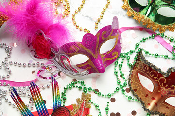 Beautiful carnival masks with confetti and decor on white background. Top view