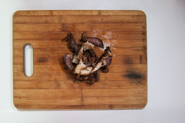 Fatty Biltong cured meat on a brown wooden cutting board.