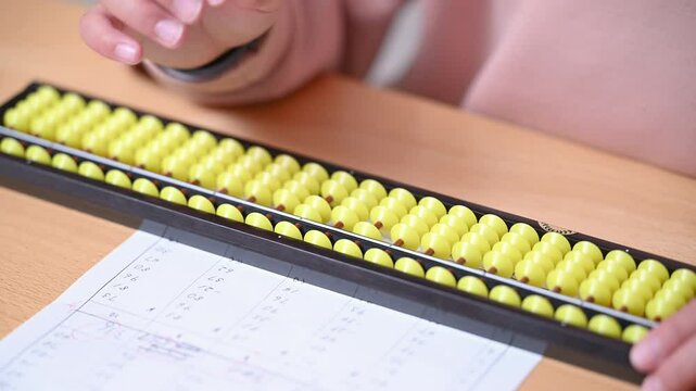 そろばん(珠算)をする小学生のクローズアップ　顔無しの手元のクローズアップの動画