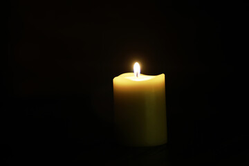 Glowing Candle in Dark Background Emanating Warm Light and Tranquility Perfect for Calm and Meditation