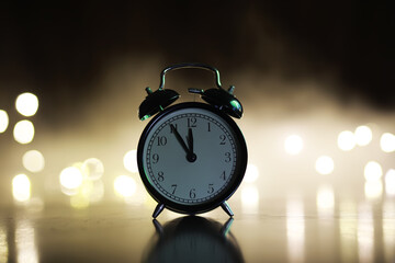 Classic Black Alarm Clock at Midnight with Bokeh Lights in the Background