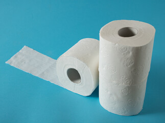 Three white rolls of toilet paper on the blue shelf in the store