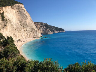 Breathtaking coastal view with turquoise sea, sandy beach, and towering cliffs