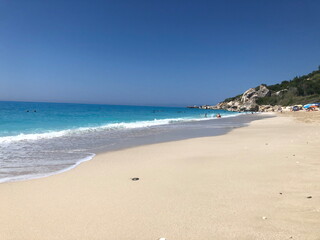 Idyllic sandy beach with turquoise sea under a cloudless blue sky