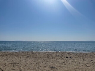Sandy beach with calm blue sea under a clear sky