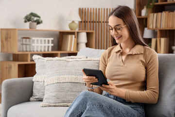 Young girl reading e-book at home