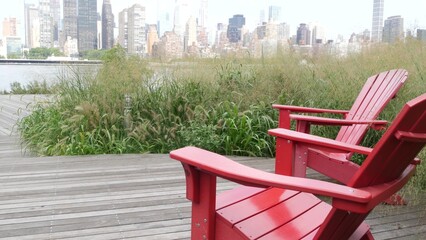 New York City waterfront skyline, Manhattan Midtown buildings, riverfront skyscrapers by East river water. Waterside cityscape view, Gantry Plaza Park, Long Island, Queens. United States. Chair bench.
