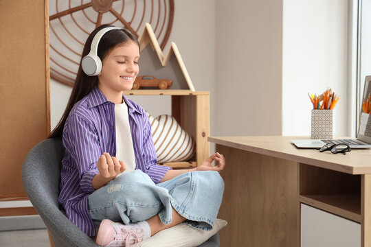 Teenage girl in headphones meditating at home