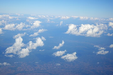 Fototapeta premium White clouds drift across the stratosphere against a blue sky. A few clouds dot the otherwise brilliant and pure sky. As if gazing up at a picturesque day, the scene is calm and tranquil.